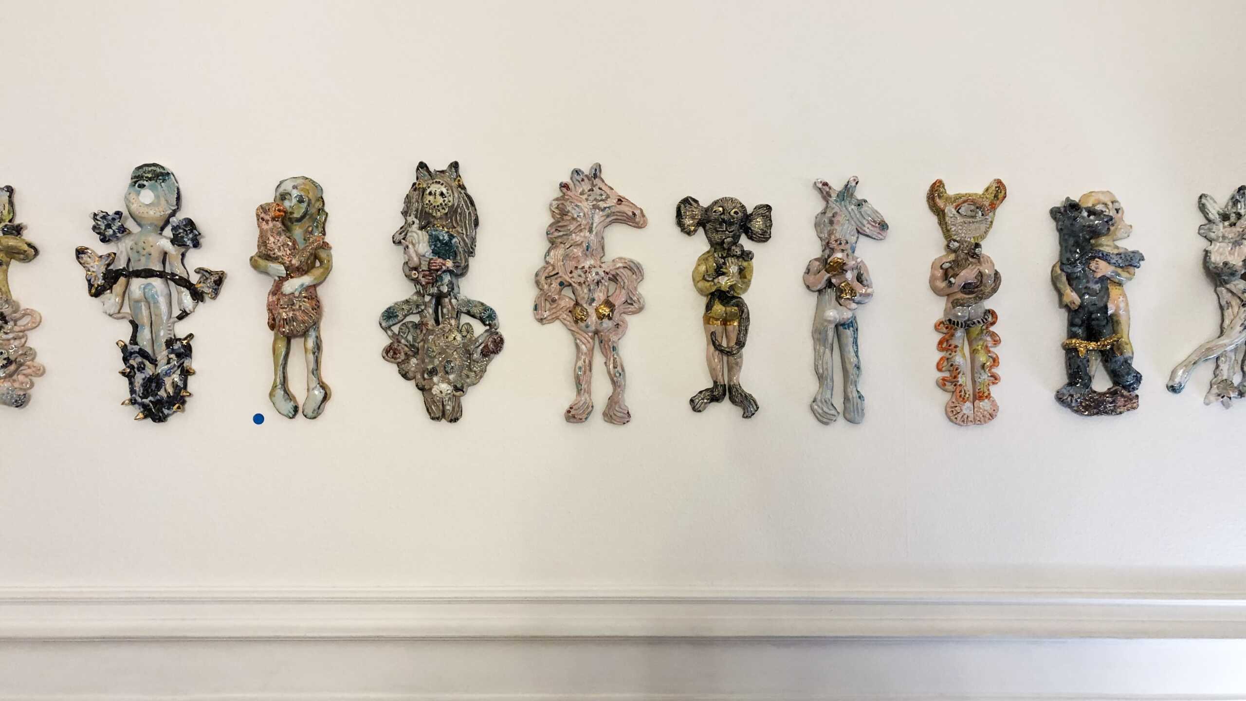 Saraï Delfendahl's amusing ceramic figures dancing on the wall